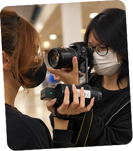 Anati looking through the viewfinder of her camera